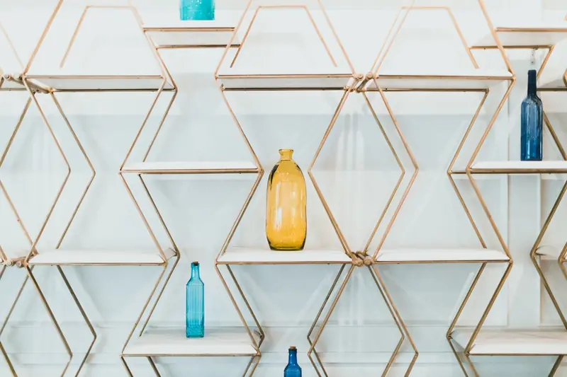 Elegant hexagonal shelves showcasing colorful glass bottles against a white background
