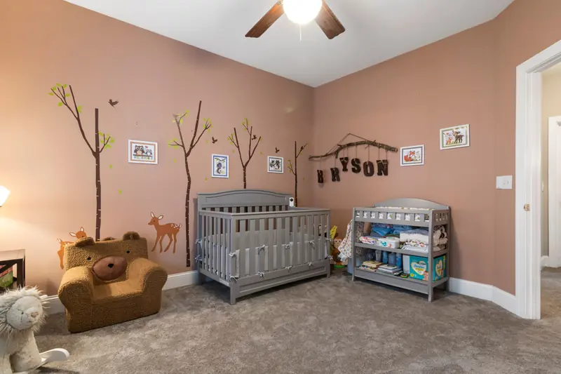 Cute nursery room interior with crib, animal-themed decor, and warm lighting