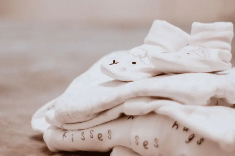 Close-up of soft white baby clothes with cute animal patterns, ideal for newborn comfort