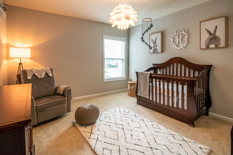 Warm and inviting baby room with elegant crib, armchair, and decor